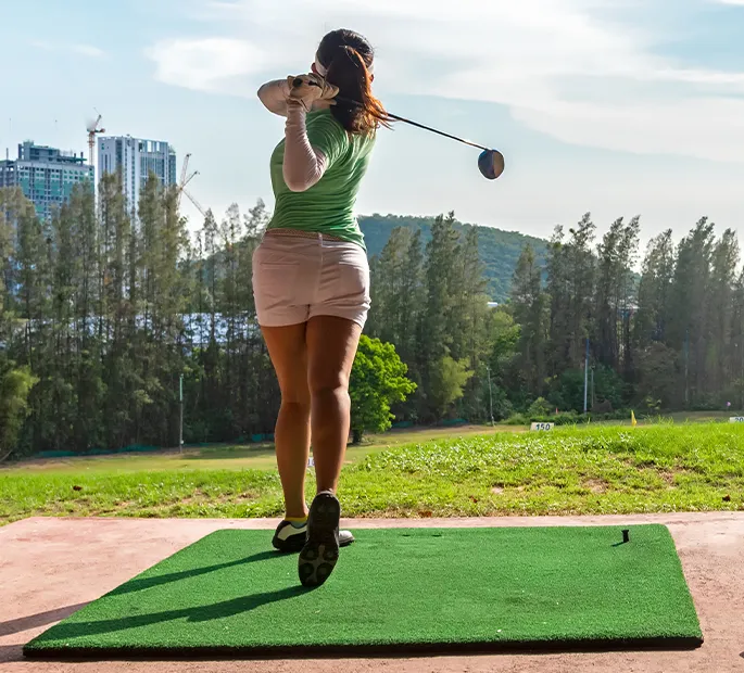Woman swing golf ball practice at golf driving range